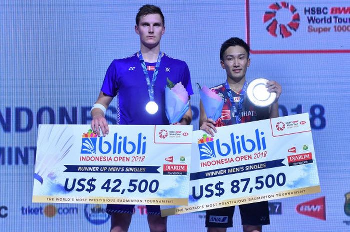 Juara Indonesia Open 2018 asal Jepang, Kento Momota (kanan) dan runner-up Indonesia Open 2018 dari Denmark, Viktor Axelsen, berpose di atas podium kampiun setelah menjalani laga final di Istora Senayan, Jakarta, Minggu (8/7/2018).