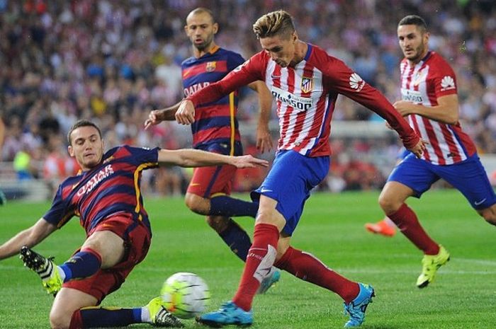 Bek Barcelona, Thomas Vermaelen (kiri), mencoba memblok tembakan striker Atletico Madrid, Fernando Torres, dalam duel La Liga, 12 September 2015.
