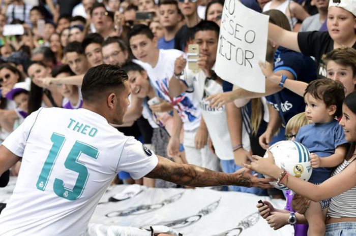 Pemain Real Madrid, Theo Hernandez, memberikan bola kepada penggemar dalam sesi perkenalan di Stadion Santiago Bernabeu, Madrid, Spanyol, pada 10 Juli 2017.