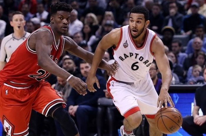 Pemain Chicago Bulls, Jimmy Butler, (kiri) sedang berusaha merebut bola yang sedang didribble pemain Toronto Raptors, Cory Joseph (kanan) pada lanjutan kompetisi NBA 2015-2016 yang digelar di Air Canada Center, Minggu (3/1/2016).