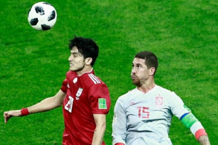 Sardar Azmoun dan Sergio Ramos berduel di udara dalam memperebutkan bola pada pertandingan Iran vs Spanyol di Kazan Arena, 20 Juni 2018.