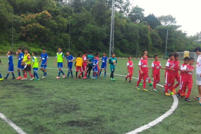 Para pemain BLiSPI Bina Sentra (baju merah) bersalaman dengan pemain Bedok Youth Soccerites serta perangkat pertandingan di lapangan 4 The Cage Sports Park, Turf City, Singapura, pada Senin (6/11/2017).