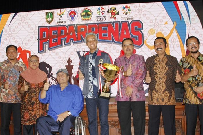 Gubernur Jawa Tengah Ganjar Pranowo (kanan) berpose dengan piala yang didapat sebagai juara umum pada Pekan Paralimpik Pelajar Nasional (Peparpenas) VIII/2017 di Solo, Senin (14/11/2017).