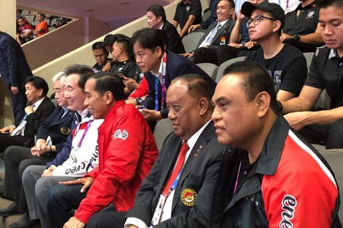 Presiden Indonesia, Joko Widodo (jaket merah), saat menyaksikan pertandingan Taekwondo Asian Games 2018 di Plenary Hall, Jakarta Convention Center, Jakarta, pada Minggu (19/8/2018).