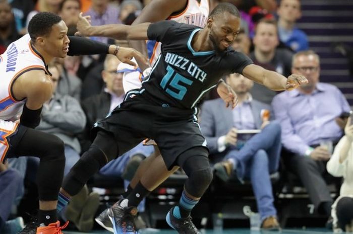 Guard Oklahoma City Thunder, Russell Westbrook (jersey putih, #0), berupaya merebut bola dari pemain Charlotte Hornets, Kemba Walker (#15), pada laga lanjutan musim reguler NBA 2016-2017 di Spectrum Center, Charlotte, North Carolina, Amerika Serikat, Rabu (4/1/2017) malam waktu setempat atau Kamis pagi WIB.