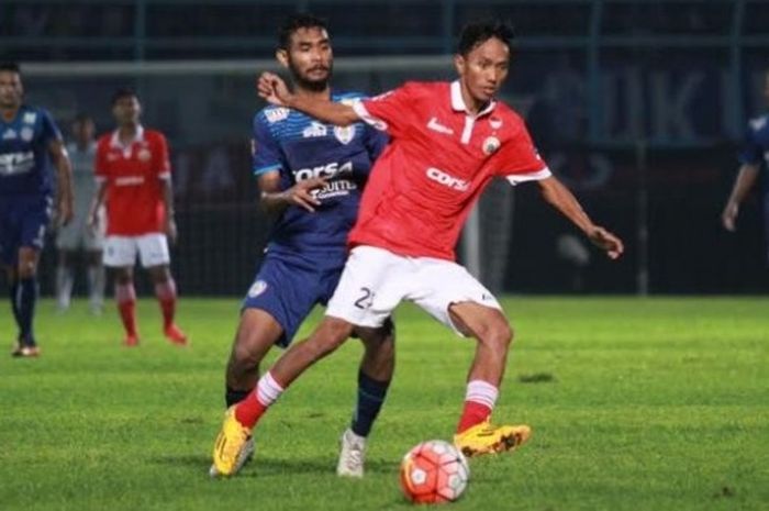 Mantan gelandang Persija, Amarzukih (depan) mencoba lepas dari pengawalan pemain Arema, Ferry Aman Saragih di Stadion Kanjuruhan, Malang, Minggu (19/6/2016) malam. 