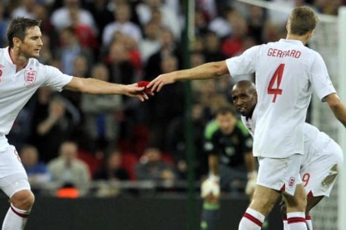 Mantan kapten timnas Inggris, Steven Gerrard (kanan), memberikan ban kapten kepada Frank Lampard (kiri) pada laga kualifikasi Piala Dunia 2014 melawan Swedia di stadion Wembley, 11 September 2012.