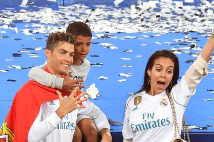    Bintang Real Madrid, Cristiano Ronaldo (kiri), berpose dengan kekasihnya, Georgina Rodriguez, dan putranya, Cristiano Junior, saat merayakan kesuksesan tim menjuarai Liga Champions seusai menekuk Liverpool FC 3-1 dalam final di Stadion NSC Olimpiyskiy, Kiev, Ukraina, pada Sabtu (26/5/2018).   