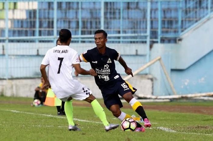 Bek senior Persekam Metro FC, Hermawan mencoba melewati penyerang PS Badung, I Ketut Tirta Nadi pada laga Liga 2 di Stadion Kanjuruhan, Kab Malang, Minggu (30/4/2017). 