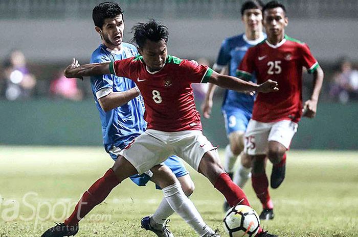   Gelandang timnas Indonesia, Muhammad Hargianto, berebut bola dengan pemain timnas Uzbekistan dalam laga PSSI Anniversary Cup 2018 di Stadion Pakansari, Kabupaten Bogor, Kamis (3/5/2018).  