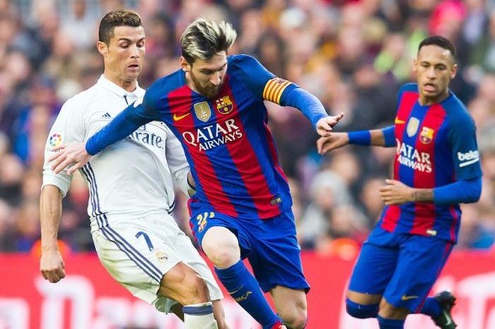 Striker Barcelona, Lionel Messi, mencoba melewati hadangan rivalnya dari Real Madrid, Ronaldo, saat kedua tim melakoni laga lanjutan Liga Spanyol 2016-2017 di Stadion Camp Nou, Barcelona, (3/12/2017).
