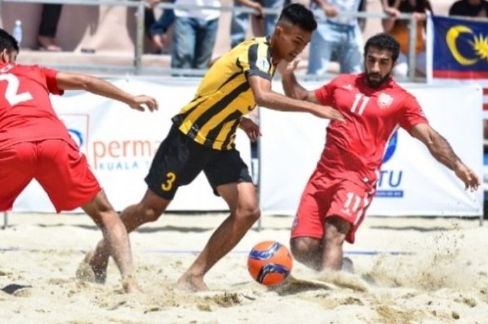 Duo pemain Bahrain, Nayef A Rahman Mohamed (kiri) dan Abdulla Abdullatif Alabdulla (kanan) mengapit pilar Malaysia, Muhammad Qushaire Asaari pada laga Grup A Kejuaraan Sepak Bola Pantai Asia 2017 di lapangan 1 Pantai Batu Buruk, Kuala Terengganu, Malaysia,  Senin (6/3/2017) siang.