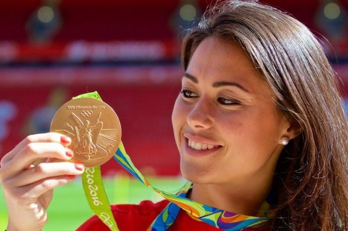 Pemain hoki timnas Inggris Raya, Samantha Quek, memamerkan medali emas yang dia raih di Olimpiade Rio dalam kunjungan melihat tribun utama baru Liverpool FC.