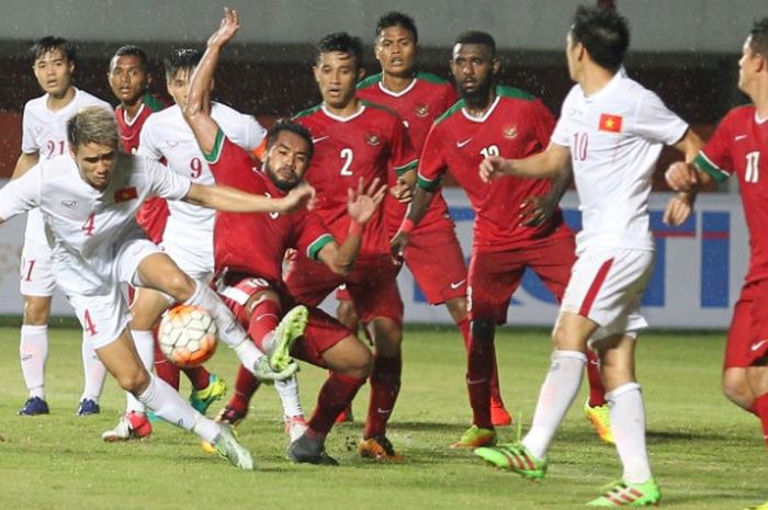 Para pemain timnas Indonesia (kaus merah) berebut bola dengan pilar timnas Vietnam pada uji coba internasional di Stadion Maguwoharjo, Sleman pada 9 Oktober 2016. 