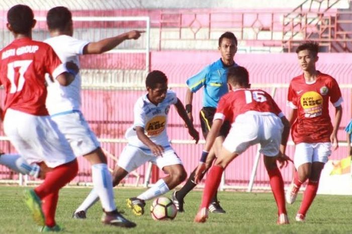 Aksi pemain depan Arema FC U-17, Ottow Sakamaka (tengah) dihadang para pilar Naga Mas Asri U-17 pada laga Grup E Piala Suratin 2017 regional Jawa Timur di Stadion Gelora Soeprijadi, Kota Blitar pada Sabtu (20/5/2017). 