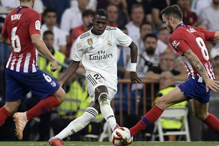 Penyerang Real Madrid, Vinicius Junior, berusaha melewati hadangan dua pemain Atletico Madrid pada pertandingan lanjutan Liga Spanyol di Stadion Santiago Bernabeu, Sabtu (29/9/2018).