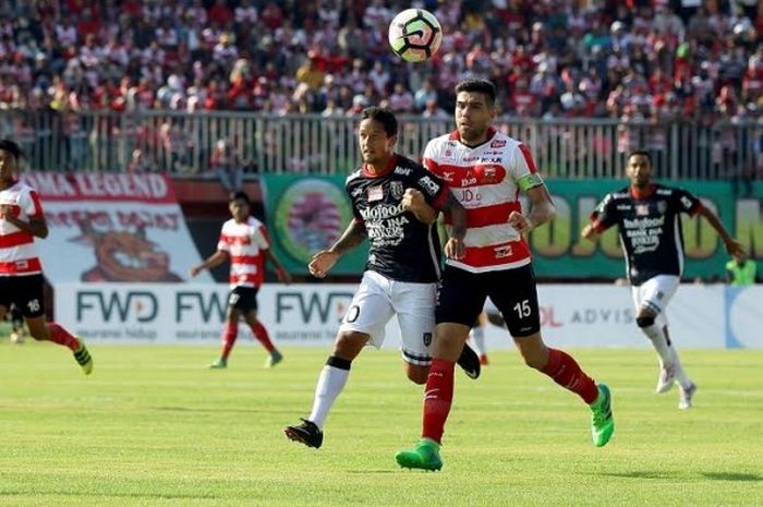 Penyerang Bali United, Irfan Bachdim (kiri) ditempel ketat bek Madura United, Fabiano Beltrame pada laga pertama kedua tim untuk Liga 1 musim 2017 di Stadion Gelora Ratu Pamelingan, Pamekasan, Minggu (16/4/2017) sore.
