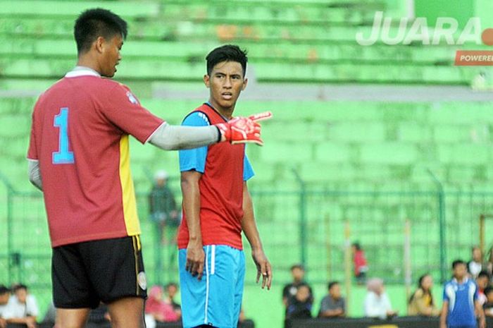 Gelandang Arema FC, Hanif Sjahbandi (kanan), berdiskusi dengan kiper Kurnia Meiga dalam sesi latihan Arema FC di Stadion Gajayana, Malang.