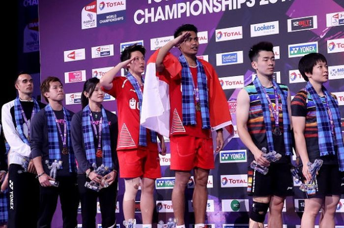  Pasangan ganda campuran Indonesia, Tontowi Ahmad/Liliyana Natsir, hormat kepada bendera saat menyanyikan lagu Indonesia Raya seusai meraih medali emas yang didapat dari Kejuaraan Dunia Bulu Tangkis 2017  yang berlangsung di Emirates Arena, Glasgow, Skotlandia, Minggu (27/8/2017). 