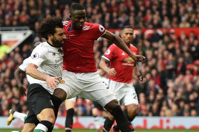 Winger Liverpool FC, Mohamed Salah (kiri), berduel dengan bek Manchester United, Eric Bailly, dalam laga Liga Inggris di Stadion Old Trafford, Manchester, pada 10 Maret 2018.