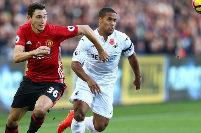 Bek Manchester United, Matteo Darmian (kiri), berebut bola dengan gelandang Swansea City, Wayne Routledge, dalam pertandingan Premier League 2016-2017 di Stadion Liberty, Swansea, Wales, pada 6 November 2016.