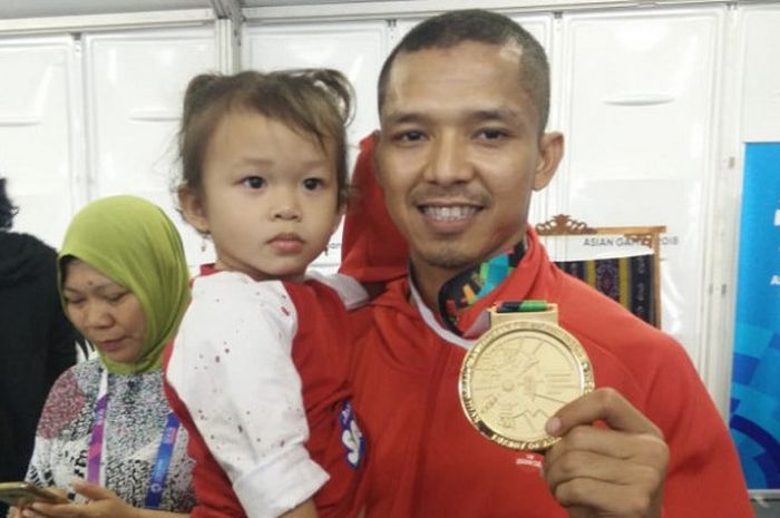 Atlet sepak takraw putra Indonesia, Novrizal, berpose dengan medali emas Asian Games 2018 dan anak pertamanya  di Ranau Hall, Jakabaring Sport City, Palembang, Sabtu (1/9/2018).