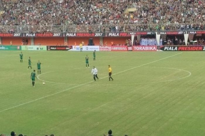 Presiden Joko Widodo (tengah) berlari ke pinggir lapangan selesai melakukan sepakan perdana pada laga pembuka turnamen pra-musim Piala Presiden 2017, yang mempertemukan PSS Sleman dengan Persipura Jayapura di Stadion Maguwoharjo, Sabtu (4/2/2017) sore. 