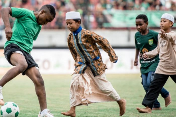 Anak-anak panti asuhan bermain dengan pemain Persebaya surabaya Minggu(18/3/2018)