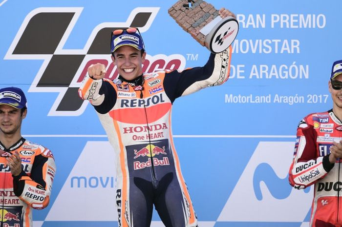 Pebalap Repsol Honda dari Spanyol, Marc Marquez (tengah), melakukan selebrasi di podium juara GP Aragon 2017 bersama rekan setimnya asal Spanyol, Dani Pedrosa (kiri), dan pebalap Ducati yang juga berasal dari Spanyol, Jorge Lorenzo.