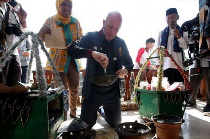Legenda sepak bola Liverpool FC, Gary McAllister, mencoba membuat kerak telor saat mengunjungi Kampung Budaya Betawi, Setu Babakan, Jakarta Selatan, dalam rangkaian LFC World Tour, Jumat (9/3/2018).