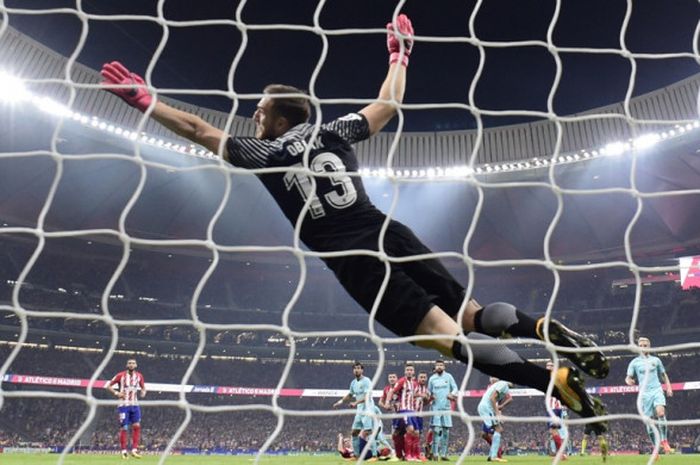 Kiper Atletico Madrid, Jan Oblak, melakukan aksi terbang dalam laga Liga Spanyol kontra FC Barcelona di Stadion Wanda Metropolitano, Madrid, pada 14 Oktober 2017.