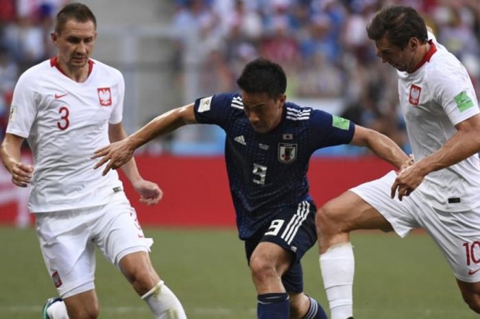 Penyerang Jepang, Shinji Okazaki (tengah), mengontrol bola di tengah kawalan pemain Polandia dalam partai Grup H Piala Dunia 2018 antara Jepang lawan Polandia di Volgograd Arena, 28 Juni 2018.