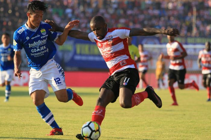  Bek Persib Bandung, Henhen Herdiana mencoba menghentikan laju pilar Madura United, Greg Nwokolo pad