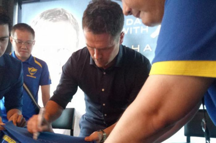 Legenda Liverpool, Michael Owen, menandatangani jersey seorang fan dalam acara konferensi pers di Bluegrass Resto, Jakarta Selatan, Senin (5/2/2018)