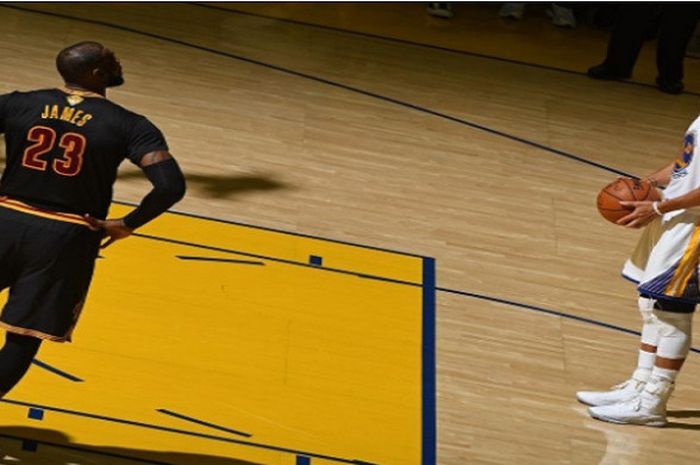 LeBron James (kiri) memperhatikan Stephen Curry (kanan) saat mengambil tembakan bebas pada saat laga final NBA musim 2016/17.