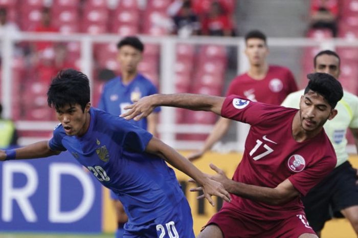 Pemain tengah timnas U-19 Thailand, Airfan Doloh (kiri) berebut bola dengan pemain timnas U-19 Qatar, Mohammed Waad Abdulwahhab laga perempat final Piala Asia U-19 2018 di SUGBK, Jakarta, Minggu (28/10/2018). 