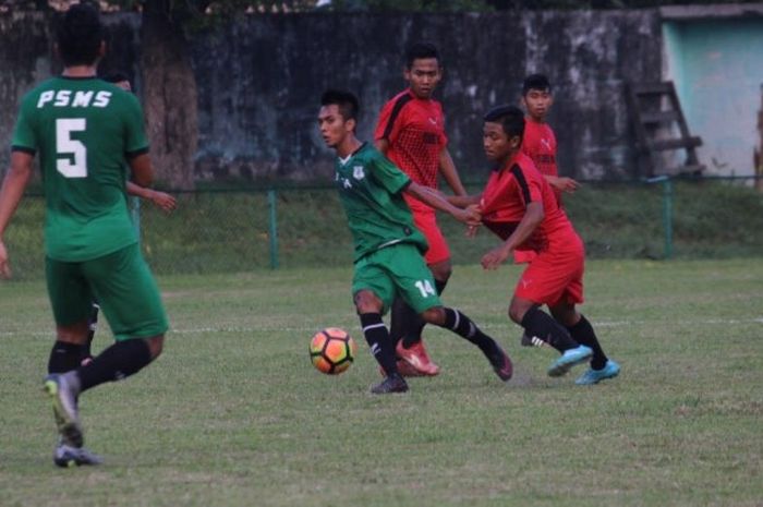 Gelandang PSMS Medan, M Nur Adli (14) mencoba lepas dari kawalan pemain Klumpang FC pada uji coba di Stadion Kebun Bunga, Kota Medan, Rabu (7/6/2017). 