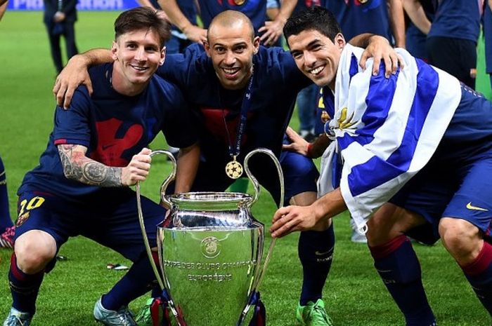 Lionel Messi (kiri), Javier Mascherano (tengah) dan Luis Suarez, berpose di belakang trofi Liga Champions yang berhasil mereka rebut pada musim 2014-2015 usai menaklukan Juventus di partai final pada 6 Juni 2015 di Olympiastadion, Berlin, Jerman.