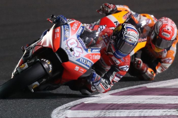 Aksi pebalap Ducati, Andrea Dovizioso dan pebalap Repsol Honda, Marc Marquez, saat balapan pada seri pertama MotoGP 2018 di Sirkuit Losail, Qatar, Minggu (18/3/2018) malam WIB.