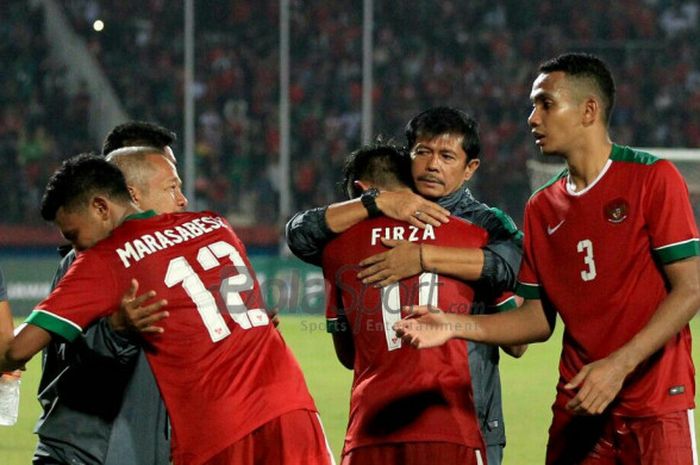           Firza Andika (nomor 11) memeluk pelatih timnas U-19 Indonesia, Indra Sjafri, usai laga Indonesia kontra FIlipina pada babak penyisihan grup Piala AFF U-19 di Stadion Gelora Delta Sioarjo, Kamis (5/7/2018).          