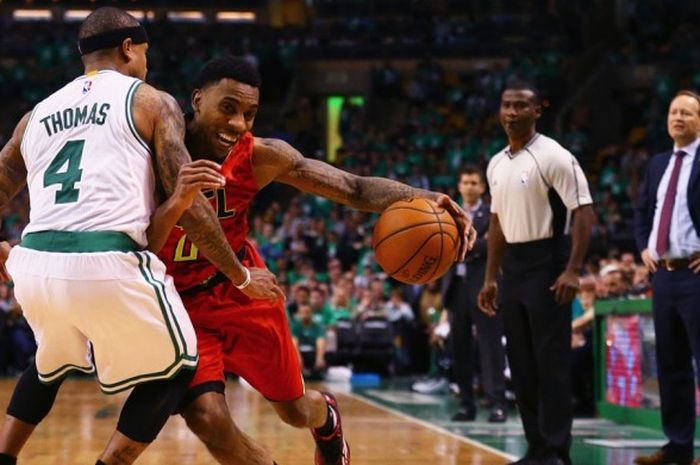 Pemain Atlanta Hawks, Jeff Teague (jersey merah, #0) berupaya melewati penjagaan pemain Boston Celtics, Isaiah Thomas (jersey putih,#4) pada kuarter keempat gim keenam babak pertama playoff NBA 2016 yang berlangsung di TD Garden, Boston, Kamis (28/4/2016) malam waktu setempat atau Jumat pagi WIB.