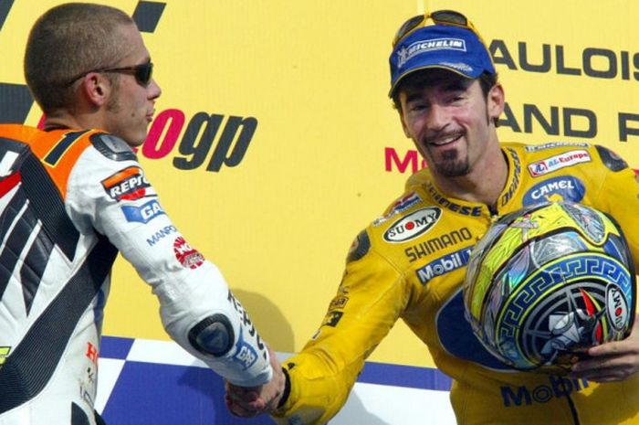 Dua pebalap MotoGP asal Italia, Valentino Rossi (kiri) dan Max Biaggi, bersalaman di atas podium.