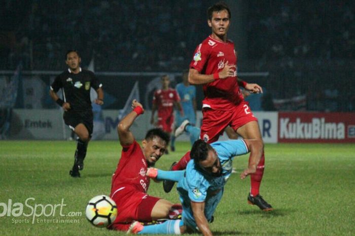   Bek Persija Jakarta, Maman Abdurrahman mengadang pergerakan gelandang Persela Lamongan, Diego Assis, pada lanjutan Liga 1 pekan ke-9 di Stadion Surajaya Lamongan, Minggu (20/5/2018).  