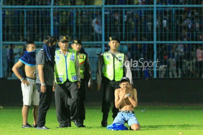 Polisi dan suporter berbincang di lapangan Stadion Kanjuruhan seusai pertandingan Liga 1 2018, Arema FC Vs Persib Bandung, Minggu (15/4/2018)