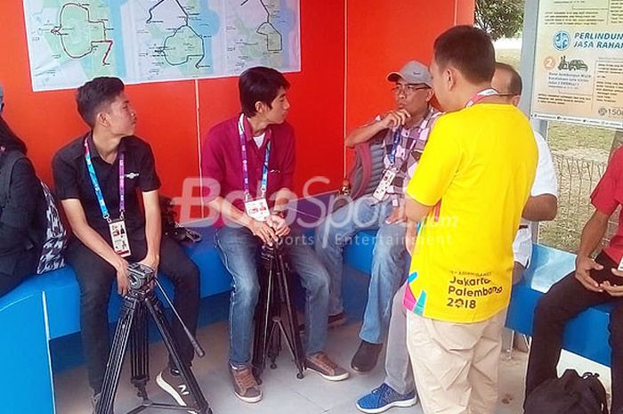 Wartawan menunggu angkutan shuttle bus dari venue tenis menuju MPC, Senin (20/8/2018) di Jakabaring Sportcity Palembang.
