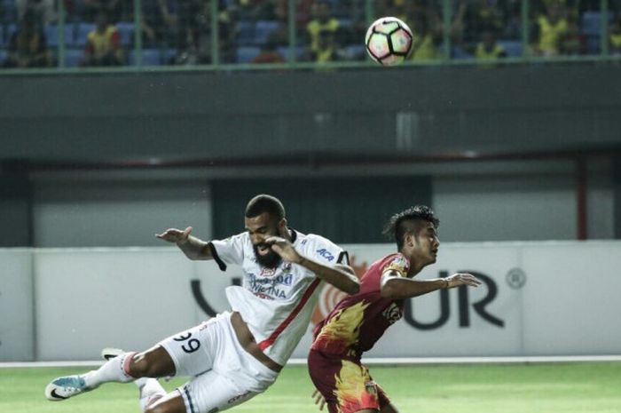 Penyerang Bali United, Sylvano Comvalius, berebut bola dengan bek Bhayangkara FC, Putu Gede, pada Jumat (29/9/2017).