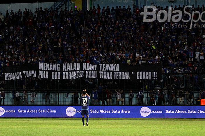 Pendukung Arema, Aremania, membentangkan spanduk berbau protes kepad pelatih Aji Santoso saat Arema melawan Pusamania Borneo FC dalam laga lanjutan Liga 1 di Stadion Kanjuruhan, Malang, pada Minggu (30/7/2017).