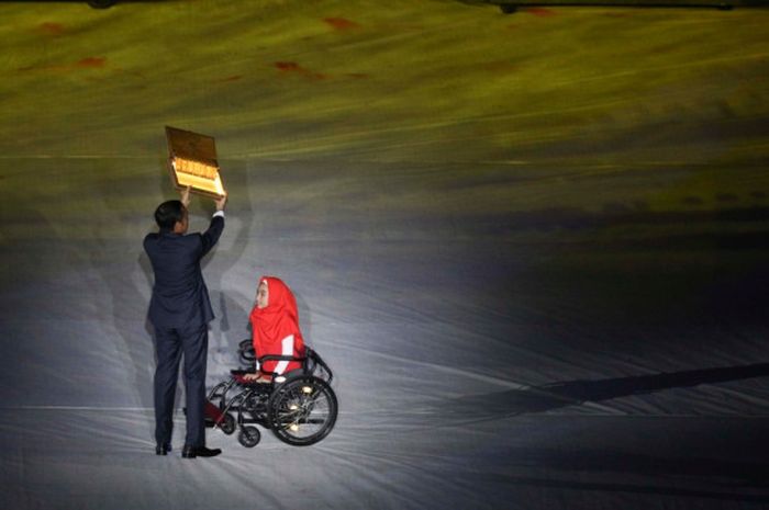 Presiden Jokowi membuka kotak berisikan kata ability pemberian Bulan Karunia Rudianti di upacara pembukaan Asian Para Games 2018 di Stadion Gelora Bung Karno, Jakarta, Sabtu (6/10/2018).