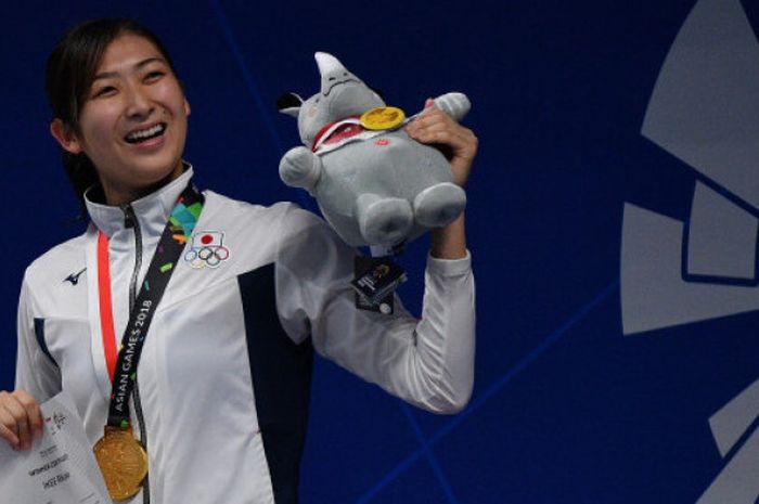 Perenang Jepang Rikako Ikee mengangkat maskot Asian Games usai upacara penyerahan medali nomor 50 met