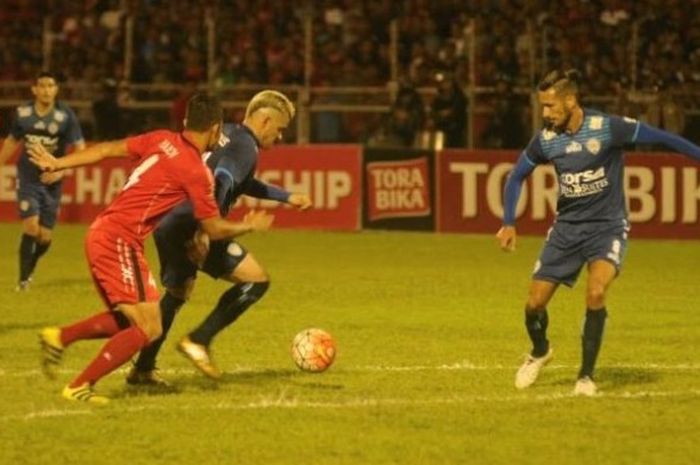 Striker Arema, Cristian Gonzales yang menguasai bola dan dapat pengawalan ketat bek Semen Padang, Handi Ramdan di Stadion H Agus Salim, Jumat (28/10/2016) malam. 